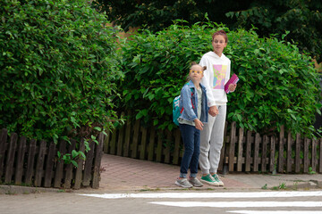 Obraz premium Older sister takes a girl with Down syndrome to school