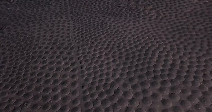 Pattern landscape with many holes to produce wine in volcanic black sand ground. Aerial view of alternative landscape. La Geria Lanzarote wine productions agriculture business