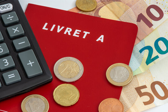 Livret A avec pi&egrave;ces et billets en euros et une calculette. Le livret A est un compte &eacute;pargne fran&ccedil;ais r&egrave;glement&eacute; dont le taux d'int&eacute;r&ecirc;t et le plafond de d&eacute;p&ocirc;t sont d&eacute;finis par le gouvernement