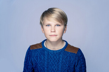 Blond teen boy 12-14 year old over gray background