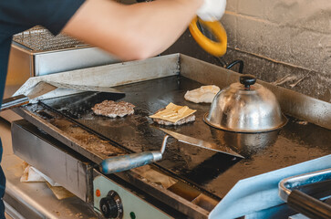 Cooking meat patties for burgers in a street cafe