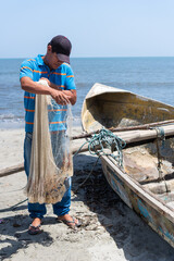 A local fisherman checks his fishing nets on a fishing boat.