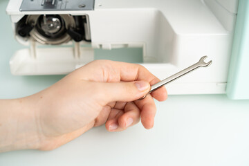 sewing machine repair, hand with key, diagnostics
