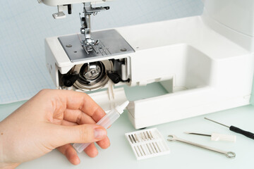 sewing machine repair, hand with engine oil, diagnostics