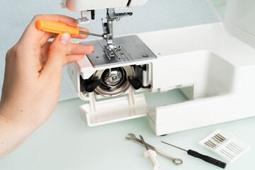 sewing machine repair, hand with screwdriver, diagnostics