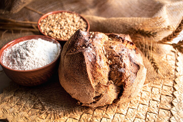 Round bread close-up on white background. Freshly baked sourdough bread with a golden crust. Baker shop context with delicious bread.