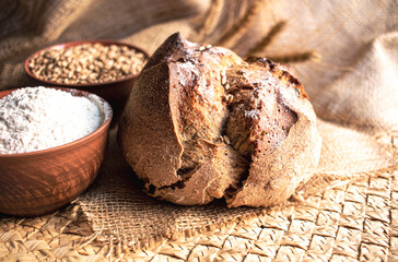 Round bread close-up on white background. Freshly baked sourdough bread with a golden crust. Baker shop context with delicious bread.