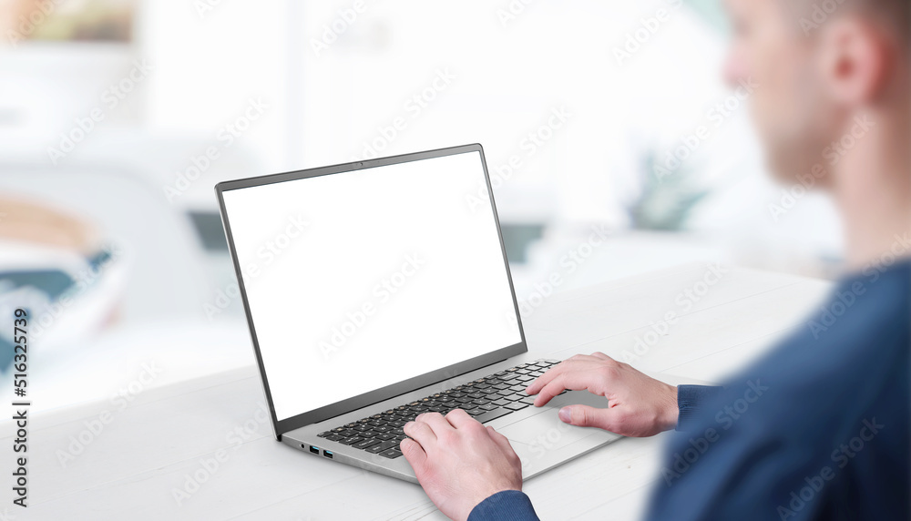 Poster Mockup image of a man working at the laptop. Clean desk with office interior in background. Isolated screen in white for web page promotion