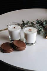 Handmade candle from paraffin and soy wax in glass with wooden wick and dry herbal. Vertical photo