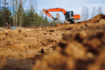 Obraz premium An excavator bulldozer works on the construction site of designer stylish homes