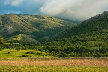 Fototapeta na wymiar Mountain village on the green hills. Beautiful mountain hills. Green mountain hills landscape. Mountain landscape