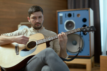 Obraz premium Modern talented guy musician play acoustic guitar compose music. Male guitarist perform melody. Musical rehearsal