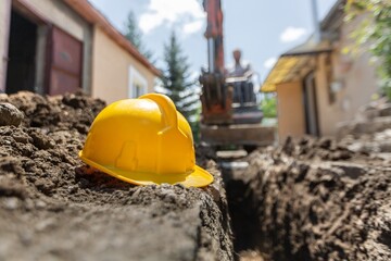 Yellow helmets placed on the cement floor are the background of the construction of blurred...