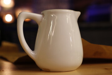 Primo piano di un Bricco da latte in ceramica che ha per sfondo le luci della notte