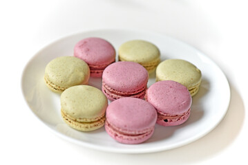 Macaroons. Sweet French desserts. Macaroons on a white plate. Macaroons on the table in the afternoon.