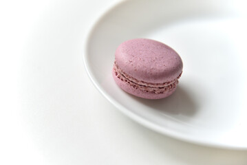 Macaroons. Sweet French desserts. Macaroons on a white plate. Macaroons on the table in the afternoon.