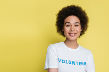 young african american woman in t-shirt with volunteer inscription isolated on yellow.
