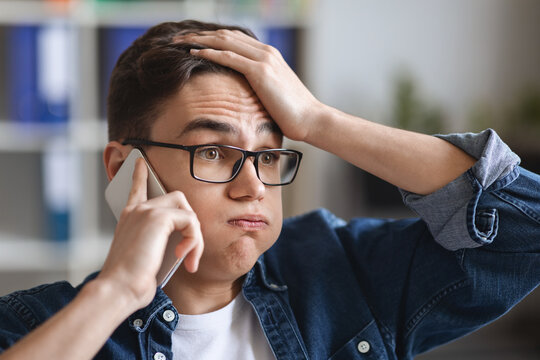 Pff. Stressed Young Man Talking On Mobile Phone And And Touching Head