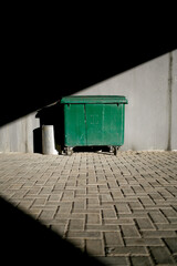 Green garbage bin in the park. copy space on shadow