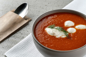 Tomato soup with sour cream, on a concrete background. Macro