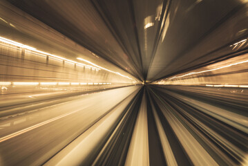 Fototapeta premium Motion blurred of train moving inside tunnel with daylight in tokyo, Japan. yollow color background concept