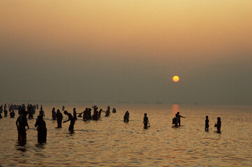 Hindu pilgrims bathing at dawn at Ganga Sagar Mela yearly pilgrimage at the mouth of the Ganges - obrazy, fototapety, plakaty