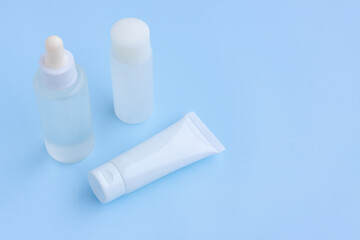 Cosmetic bottles on blue background