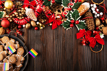Christmas background of tray with gingerbread cookie men and rainbow flags on wooden table