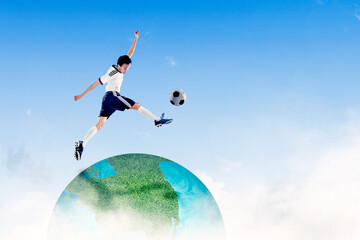 Male footballer kicking a ball on the globe