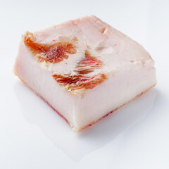 piece of lard on a white acrylic background