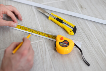 Man hands take a mark by pencil after measuring. Repairing at home.