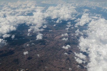 Aerial view of landscapes through fluffy white clouds © Squaresphere/Wirestock Creators