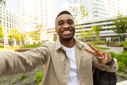 African american man takes a selfie, smiles on the background of the city