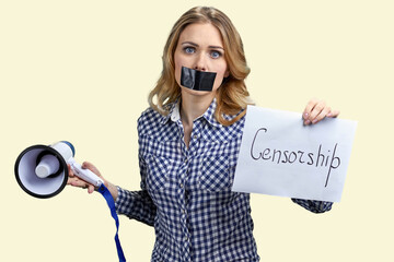 Upset young woman with black tape over mouth. Isolated on white background. Censorship concept.