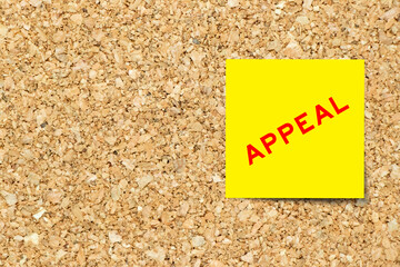 Yellow note paper with word appeal on cork board background with copy space
