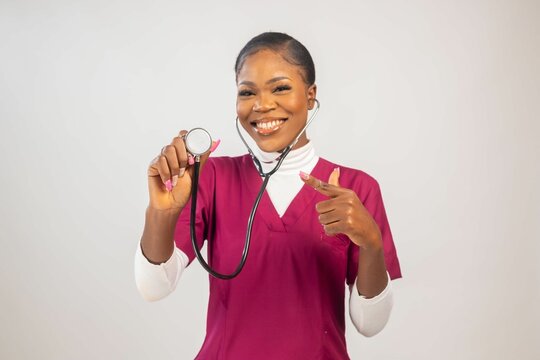 Black woman holding a stethoscope and smiling at the camera.