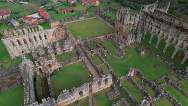 Tourists On Historical Ruins Of Rievaulx Abbey Near Helmsley In The North York Moors National Park, North Yorkshire, England. Aerial Drone Shot