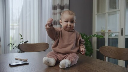 Baby boy infant kid waving his hand in a greeting gesture