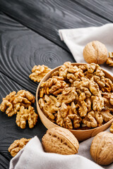 dried walnuts on a black rustic wooden background