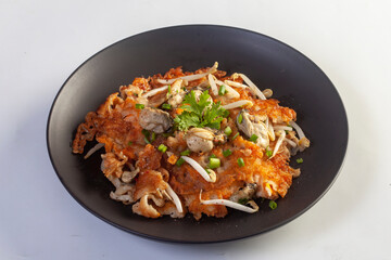 Hot pan of crispy fried oyster omelette served with bean sprout and spicy sauce.