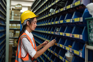 Portrait Asian women staff worker Standing counting and inspecting products in the warehouse.