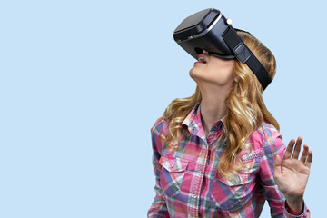 Young casual woman uses virtual glasses on color background. Space for text.