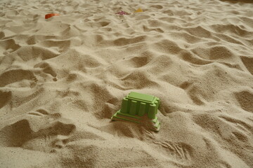 green collapse plastic toy in the sandpit for design for housing market concept