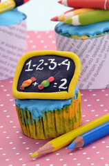 Back to school cupcakes and cookies on school table background.