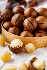 fresh macadamia nuts on a white wooden rustic background