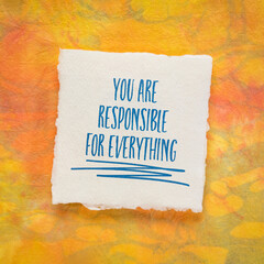 you are responsible for everything - inspirational reminder note on a sheet of handmade paper, take responsibility and personal development concept