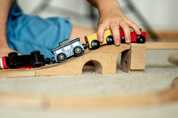 a boy at home in a room is building a railway, a child is playing with a toy train. Educational...