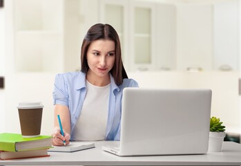 Happy young woman student learning at home looking at laptop computer watching online webinar, having virtual work meeting