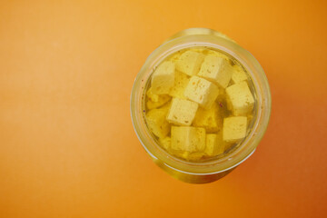 cheese cube , olive and herbs in a container on table 