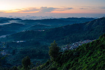 Morning sunrise view of the hills in Ooty with blue tinted landscape and Orange sky